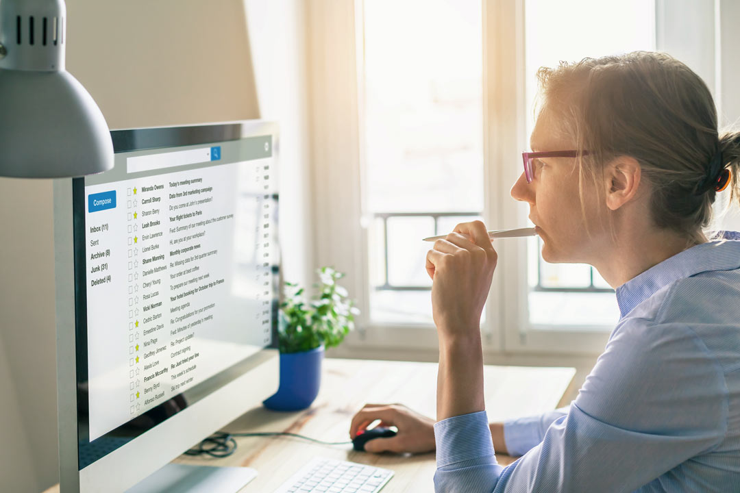 Woman with pencil at computer creating a digital marketing CV.